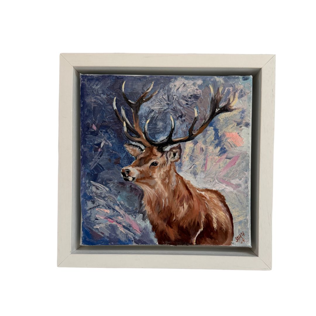 Small framed oil painting of a majestic stag with intricate antlers, set against a serene blue, white, and pink background. Perfect for nature and wildlife art lovers.