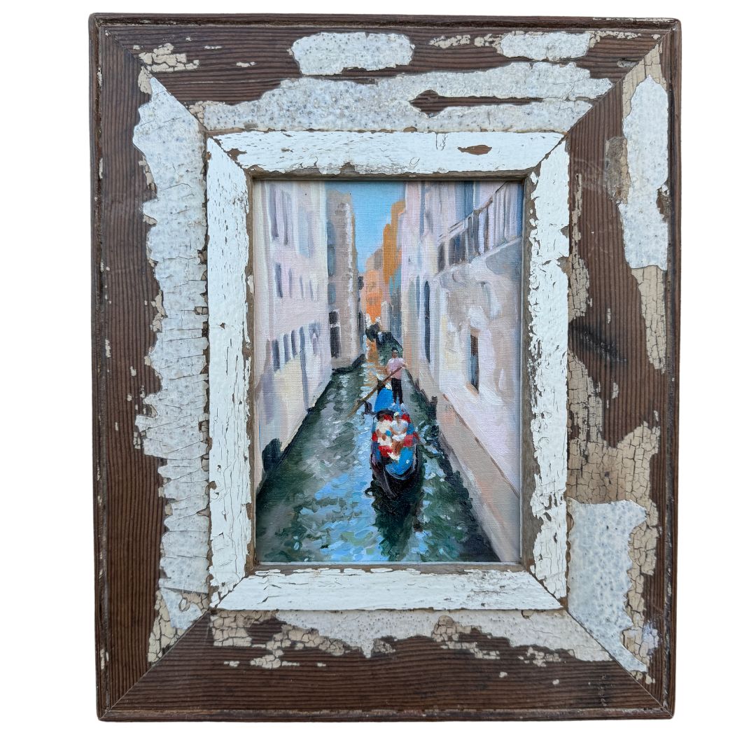 A serene framed Venice oil painting of a gondola gently gliding through a calm Venetian canal, surrounded by historic architecture under a clear sky.